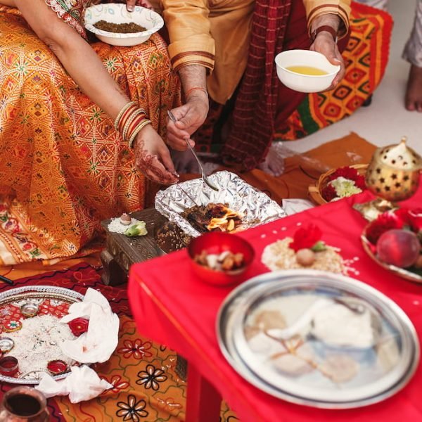 Species and fruits surround Indian parents preparing paste for newlyweds